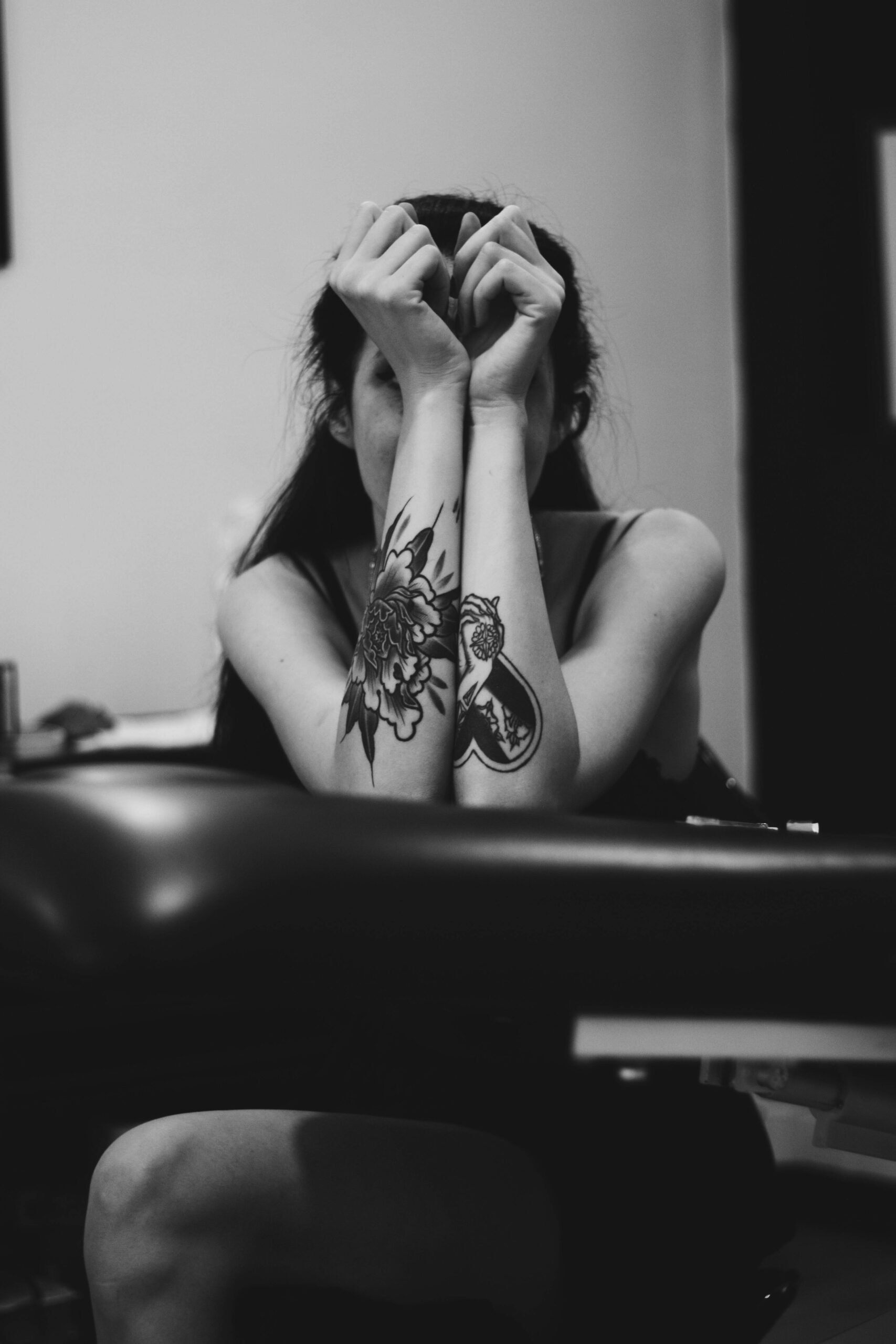 An image of a person with tattoos on their forearms, which are covering thier face.